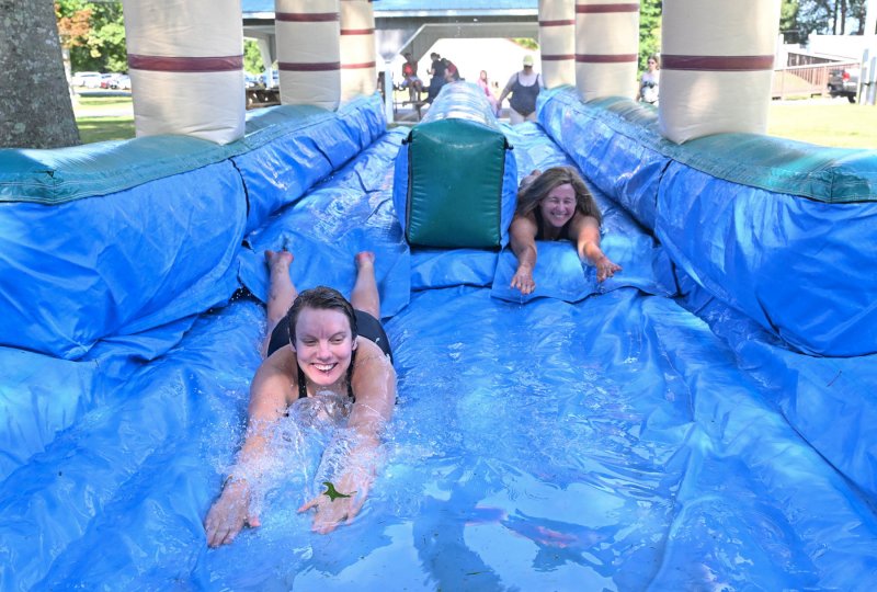 Sara Giles, left, slides on the inflatable pool slide while staff member Lori Smyth tries to keep pace.