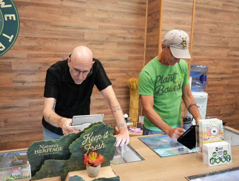 Customers Greg Anglisano, left, and Rich Ferrandino browse the available products.