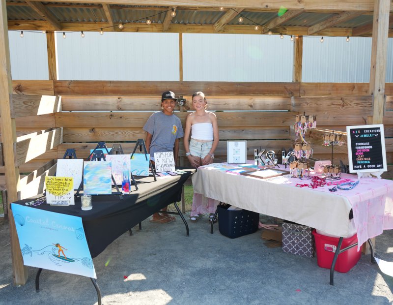 Seventh-graders Zoe Kemmerlin, left, and Katie Nauman work neighboring booths.