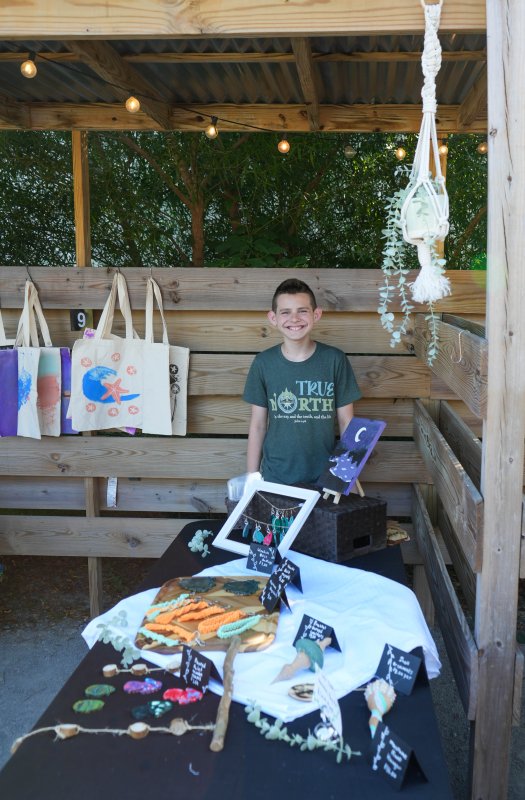 Colby Todd, a rising seventh-grader at Mariner Middle School, offers many unique creations, including wooden resin magnets and earrings, fractal burned wooden coasters, poured paint wooden shapes, wood and shell ornaments, macrame keychains, and a macrame hanging plant holder.