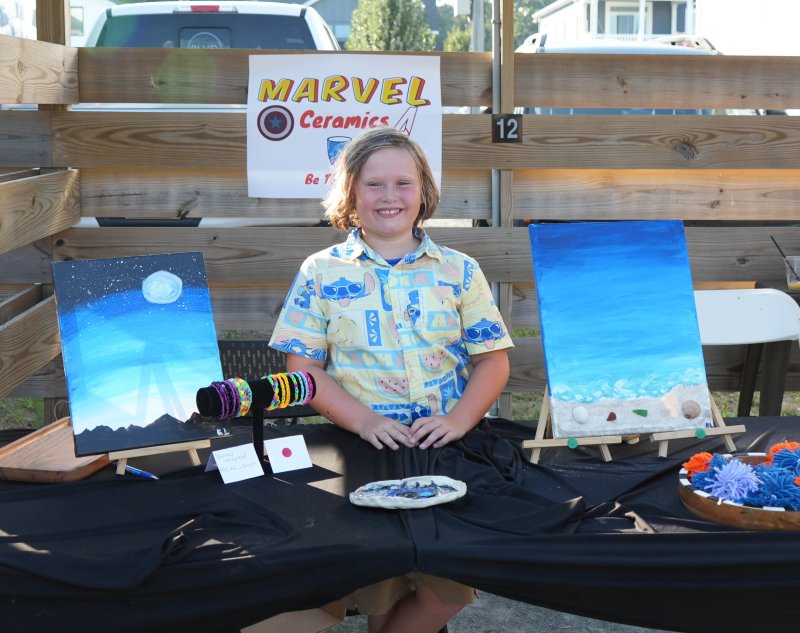 Fourth-grader Kai Lofland sells colorful bracelets, ceramics, abstract creatures and paintings, one of which features real sand and shells.
