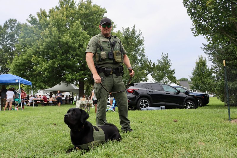 Sgt. Travis Anderson stands with Cash of the Delaware Natural Resources Police Fish & Wildlife Unit.