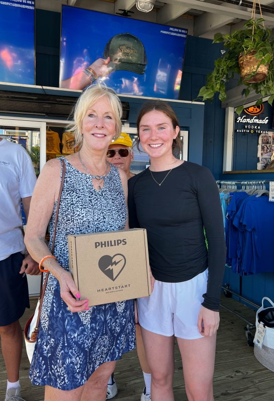Laura Ashby, left, holds a boxed AED that was donated by Alex Davis, a representative from Cardio Partners.