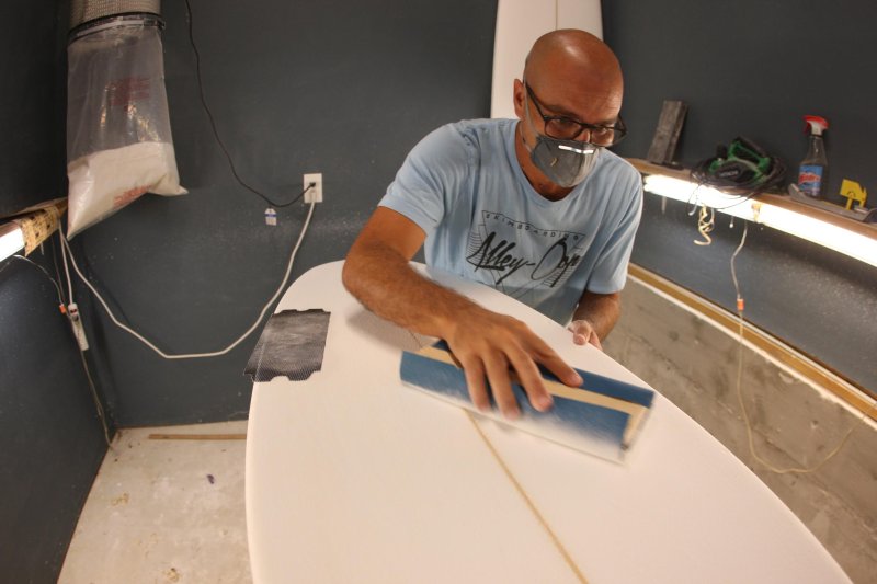 Rehoboth Beach resident Jamie Celano works on a surfboard in his home shop. TJ HEALY PHOTOS