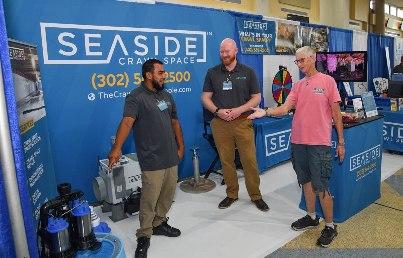 Cheryl Stewart, right, gets info on a sump pump from Melvin Melendez and Seaside Crawl Space owner Nick Luzak.