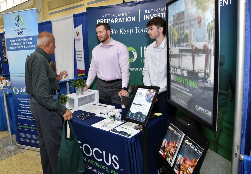 Amolak Sehgal, left, gets info on retirement from Greg Holman and Noah Layfield from InFocus.