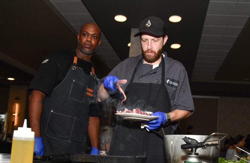 Herbert Arguez, left, and Rex Sauers prepare the chargrilled octopus for the first course for The Veranda.