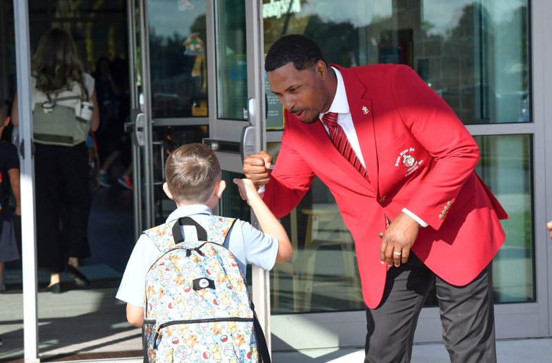 Cape graduate Malik Lopez of the Lewes Men of Achievement gives a fist bump to a student on the first day of school at H.O. Brittingham Elementary in Milton. DAN COOK PHOTOS
