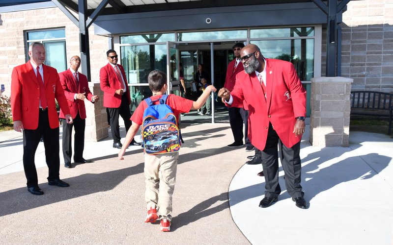 Cliffvon Howell and the community-based organization Lewes Men of Achievement welcome a student to the 2025 school year at H.O. Brittingham Elementary in Milton.