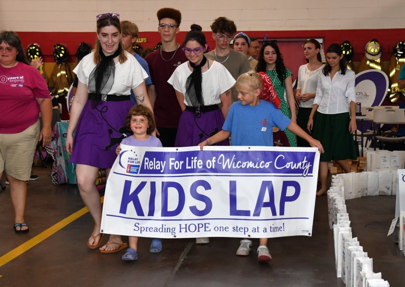 Addison Hood, left, and Izzy Lathrop holds the kids’ lap banner during the walk.
