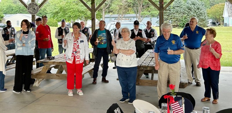 Attendees at American Legion Post 28’s 9/11 remembrance ceremony light candles and sing “God Bless America.”