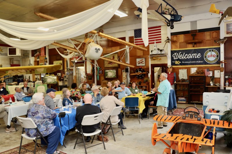 John Chirtea, standing at right, welcomes fellow pilots from the United Flying Octogenarians at his hangar at Eagle Crest Sept. 17. Pilots have to be at least 80 years old to be members of UFO. Chirtea is 87. BILL SHULL PHOTOS