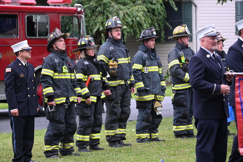 Members of the Lewes Fire Department watch the ceremony in their turnout gear.