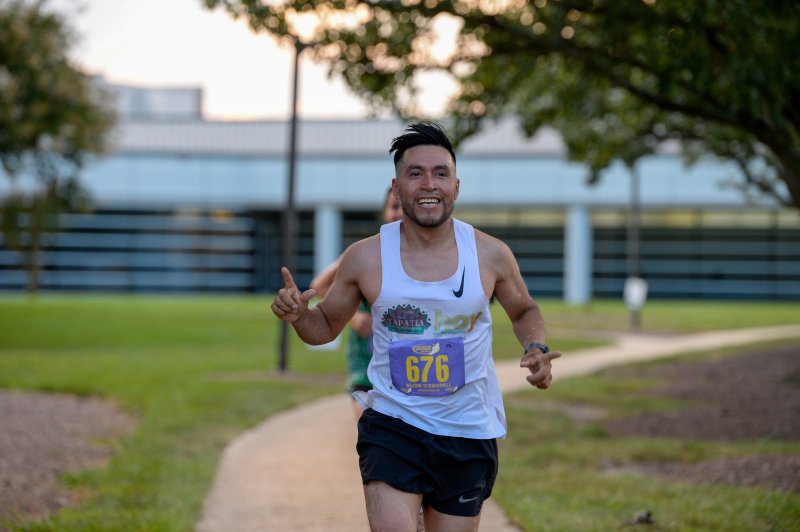 Francisco Puac crosses the finish line at the Run, White & Blue 5K in 18:27.