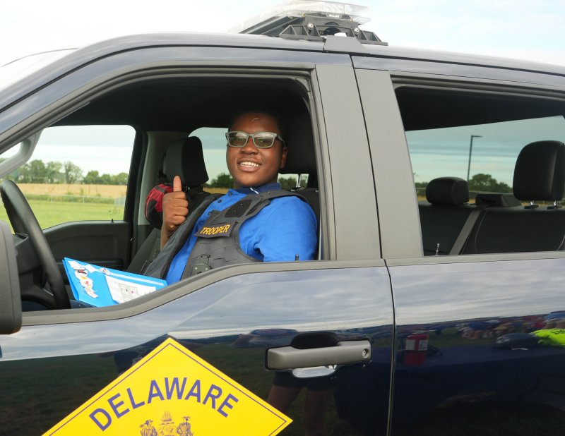 Student Isaac Francois gets comfortable in the driver’s seat of a Delaware State Police patrol car.