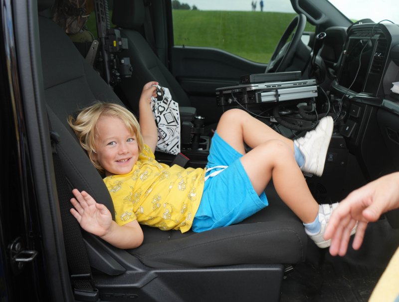 Kellan Sayler hangs out in the front seat of a Delaware Natural Resources Police car.
