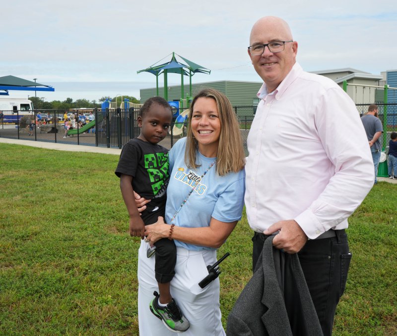Ahmid Soto, a student at Little Vikings, is held by Principal Elizabeth Cherico. They’re joined by Sen. Russ Huxtable, D-Lewes.