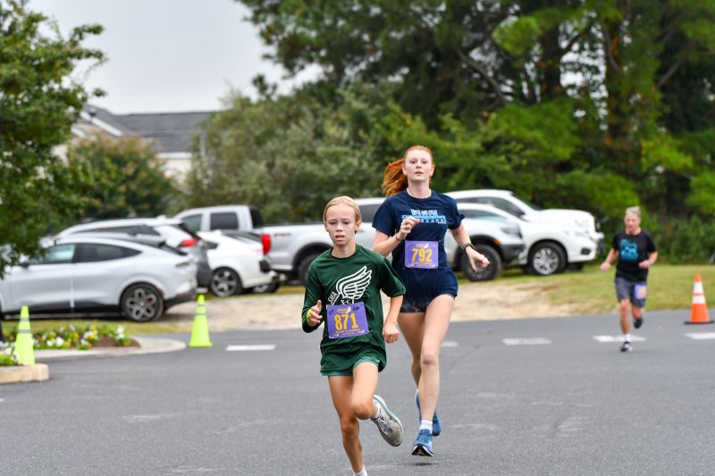 Kyla Romanczuk, 11, wins the women’s race in 20:25. Runner-up Olivia Montini finishes just behind in 20:25.9.