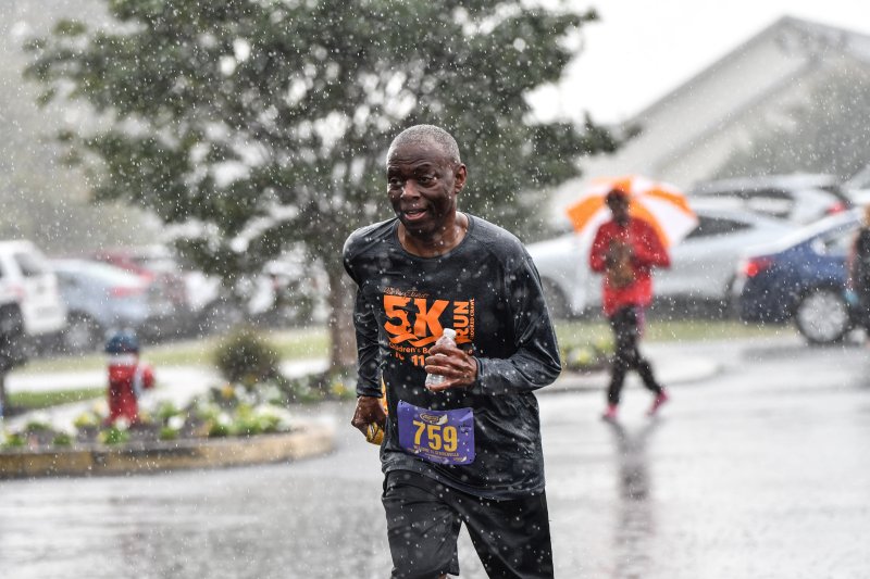 Arthur Wright, 72, runs in the rain.