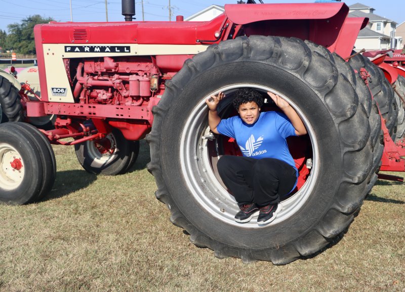 Malcolm Freeman shows just how big the tires are on a Farmall tractor at the 2024 Drive Your Tractor to Church day at Israel United Methodist Church near Lewes. BILL SHULL PHOTO
