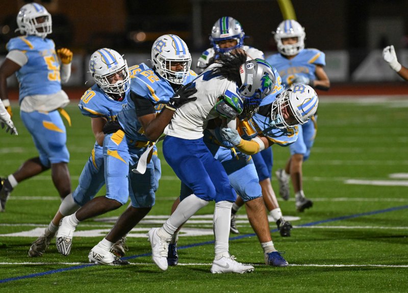 Hawks’ ball carrier Ayden Jones gets mobbed by the defense.