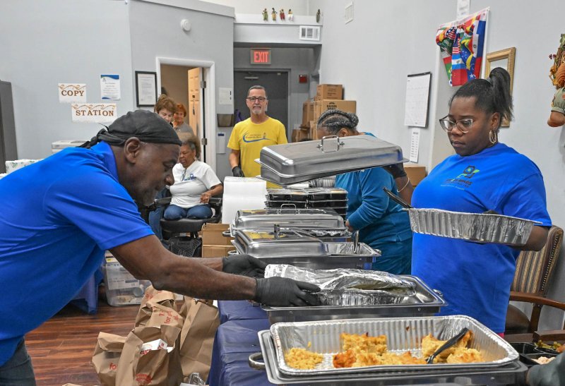 Sherrod Pearsall replenishes a tray of food.