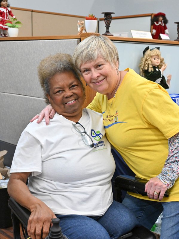 Founder and CEO Helena Gibbs, left, gets a hug from volunteer Deb Norton of Westminster Presbyterian Church.