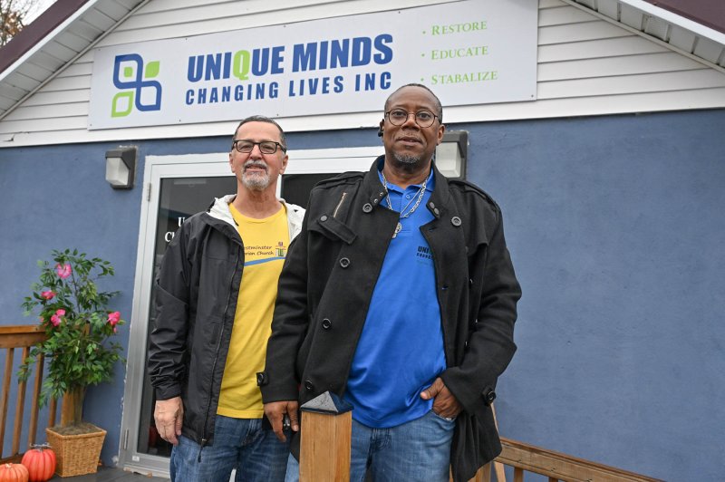 Westminster Presbyterian Church volunteer Jim Miller, left, and Unique Minds Changing Lives Food Program Coordinator Andree Mosley pose at the entrance.