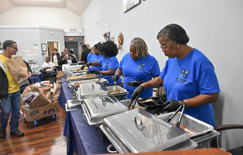 Servers load up the dinner trays to be handed out at the giveaway.