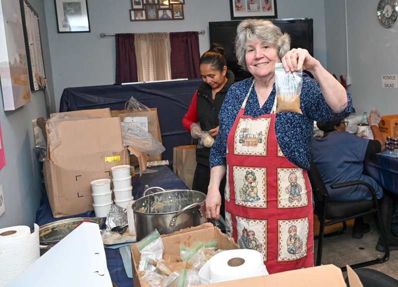 Preparing packets of gravy are Daphne Brown, member of Unique Minds Changing Lives’ board of directors, right, and Olinda Santizo.