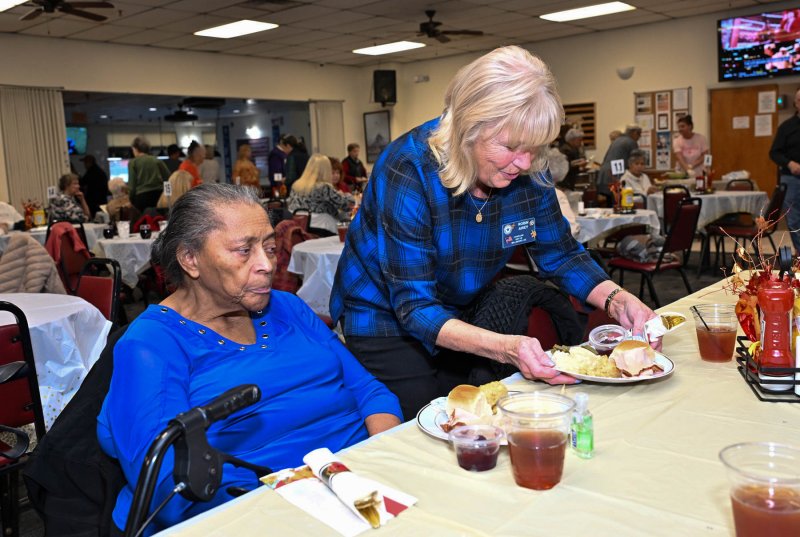 American Legion Post 28 Chaplain Robin Airey serves a tasty meal to Bettie Harmon.