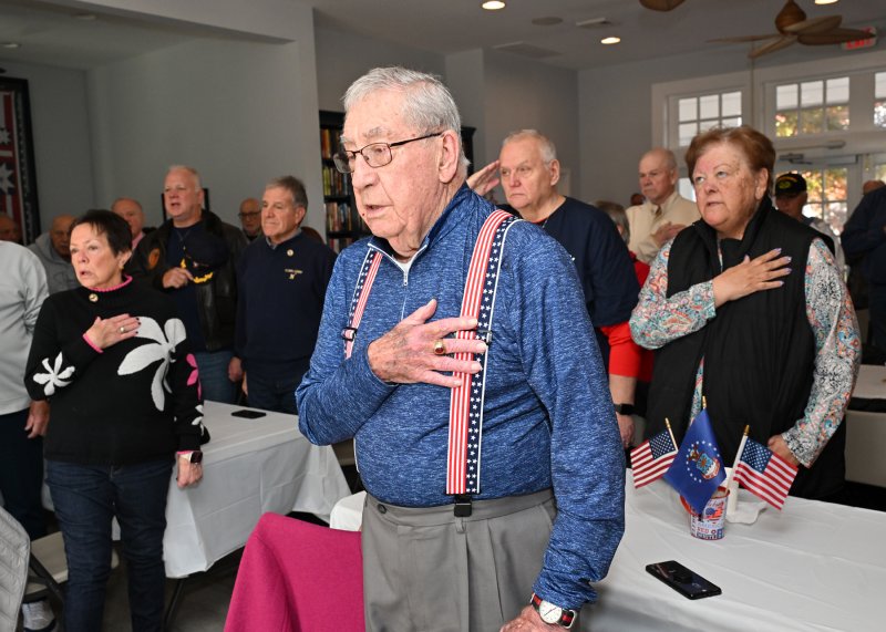 Navy veteran Jim Pellington sings along to the national anthem.