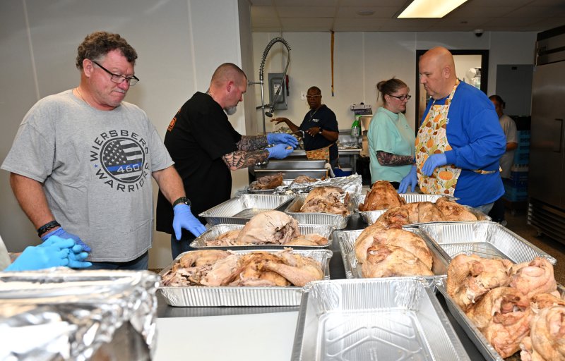 Brian Murray, left, is gloved up and ready to carve the turkeys.
