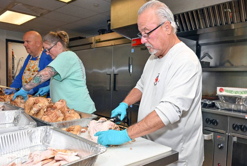 Volunteer Lou DiAmico carves the turkey.
