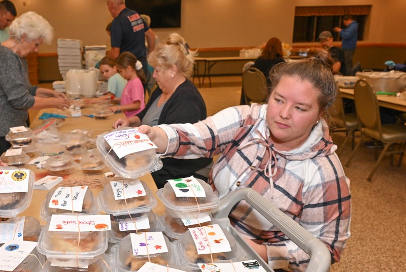 Rachel Platt attaches Happy Thanksgiving notes that were made by the Cypress Hearts & Hands 4-H Club led by Jodie Gravenor.