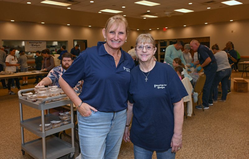 Badges for Blessings Secretary Cathy Bassett, left, stands with President Cindi Susi.