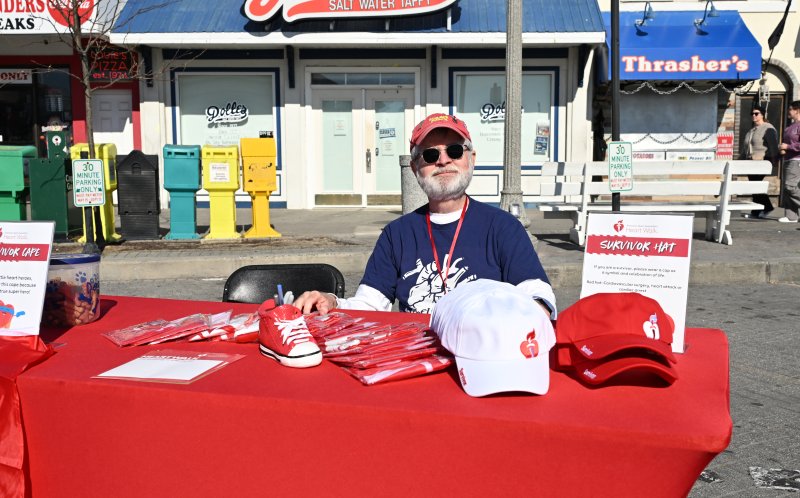 Vic Caristrum, who had a heart transplant, hands out hats to survivors.