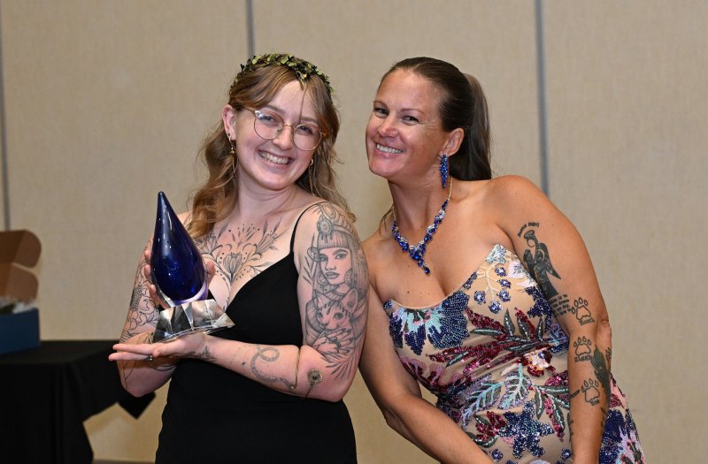 Alyse Ritzler, left, receives the Rookie of the Year Award from Grass Roots Rescue founder Karli Crenshaw.