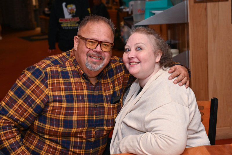 Getting a hug from Katie Arietta is family friend Bryan Hecksher.