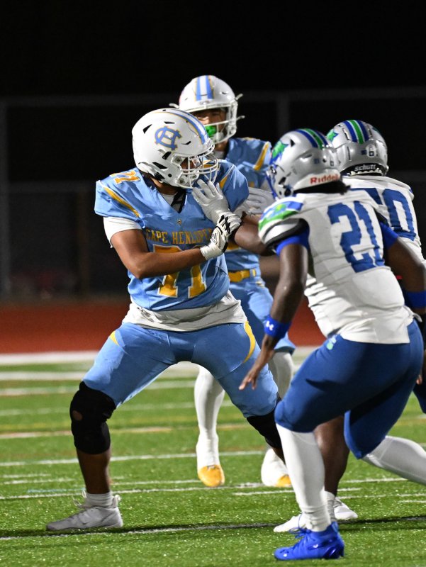 Cape lineman Jayson Cohen carries out his block despite the face mask.