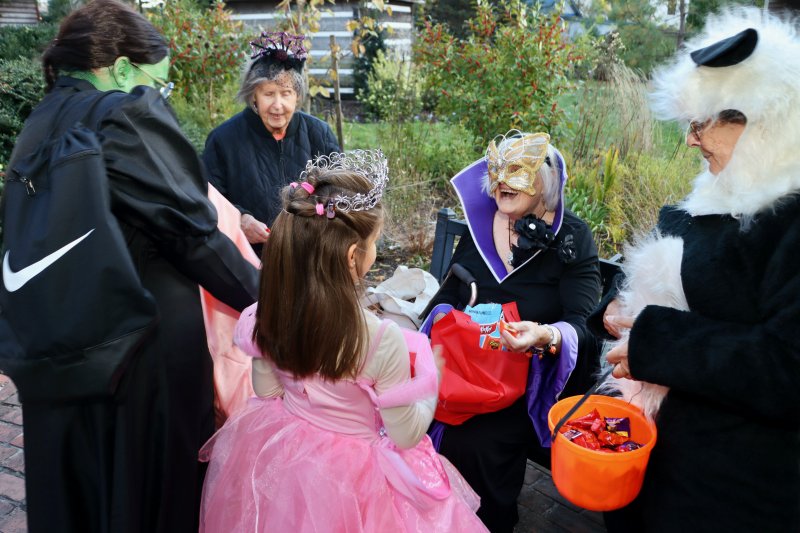 Sue Crawford, seated, is very popular as she hands out candy in Zwaanendael Park.
