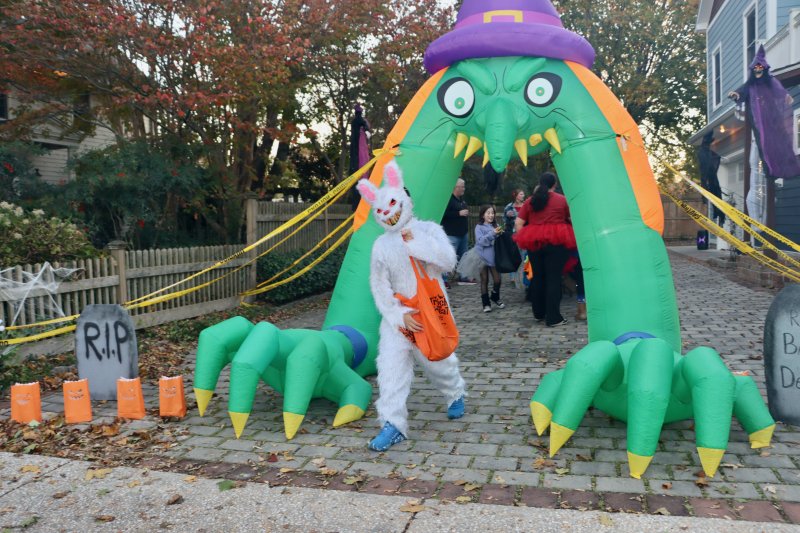 A trick-or-treater dressed as a rabbit walks out of a monster’s mouth on Coleman Avenue.