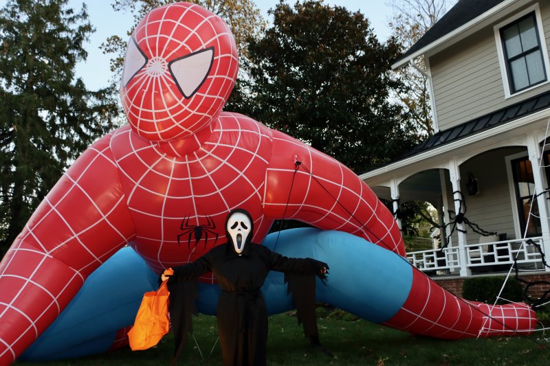 Ryder Jones in a Scream mask poses with the giant Spiderman at the house at Manila Avenue and Kings Highway.