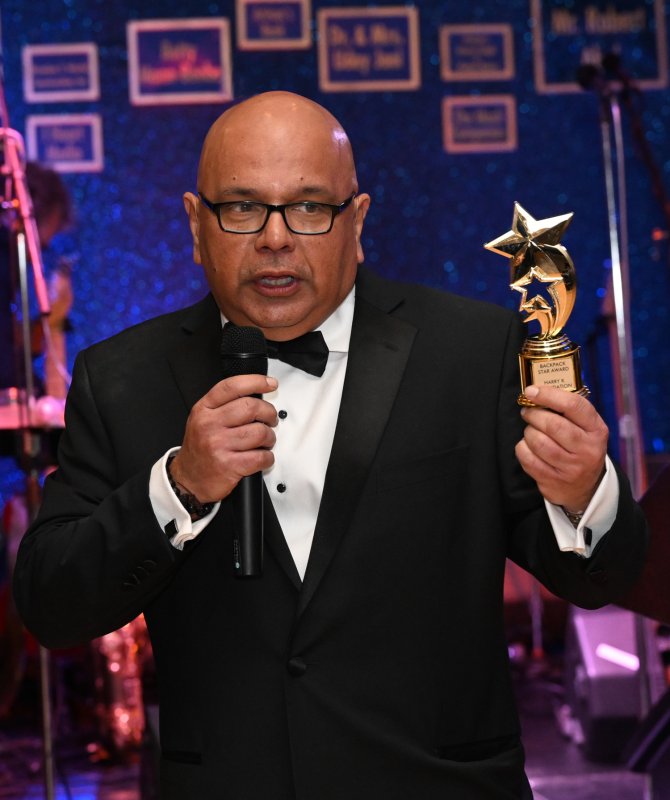Dr. Uday Jani holds one of the trophies awarded to anyone who bids for 13 or more backpacks.