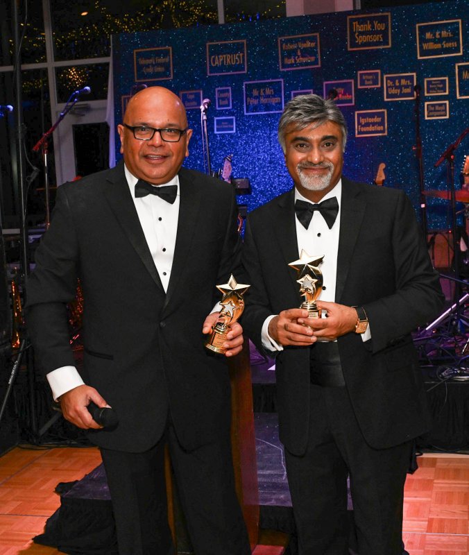 Dr. Uday Jani and Harry Keswani display the Backpack Star Awards trophies given to attendees who purchased 13 or more backpacks.