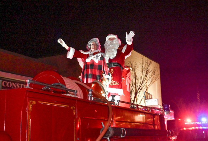 Santa and Mrs. Claus wave to the crowd at the annual Milton Christmas parade. DAN COOK PHOTOS
