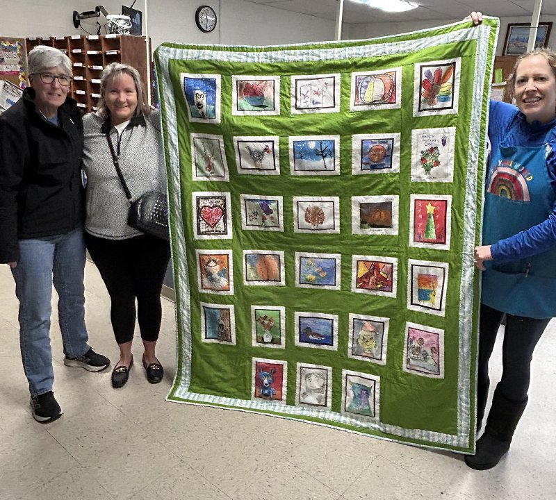 Locals Nancy LaFontaine and Melanie Redmond present a blanket made with quilt blocks purchased from Artsonia to East Millsboro Elementary art teacher Clara Kelly. SUBMITTED PHOTO