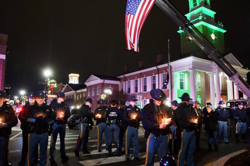 State troopers hold candles in memory of their fallen colleague, Cpl. Matthew T. “Ty” Snook, at a candlelight vigil in Georgetown on Dec. 28. BILL SHULL PHOTOS