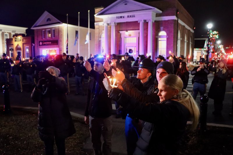 People are asked to raise their candles as a symbol of chasing away darkness from the community.