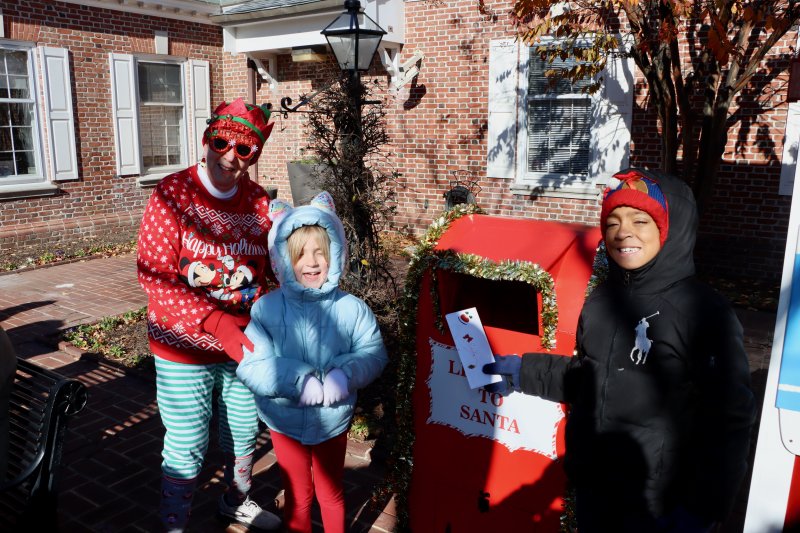 Ethan Foos, right, drops the first letter to Santa in the mailbox on Second Street.